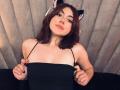 SpencerLe with brown cat ears, pulling down black spaghetti strap top, showing small tits, light skin, wavy brown hair, and a playful smile.