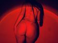 Tisia's butt is prominent in red lingerie, her long brown hair cascading down her back. She's wearing a thong that highlights her round, curvy ass. Red light.