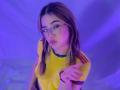 ElodieGardner with glasses, pouty lips, yellow shirt, red stripes, brown hair, pointing, purple lighting, wrist bracelet, looking up, cute, sexy.