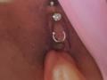 FrenchShanna's brown pussy with a silver heart and crescent moon butt plug, being gently spread by a finger.