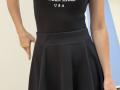 Rorria's black dress has a flared skirt, showing her ass, with her hand on her hip, wearing a tight top, her skin is light.