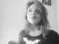 SophieHill with messy hair, looking up, wearing a Batman shirt, black and white, soft light, slightly parted lips, upper body, casual, slightly seductive, medium shot.