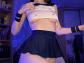 Keiri with her small tits, lifting a white sailor top, showing her bare breasts, wearing a black pleated skirt, white panties, black wristbands, in a dimly lit room.