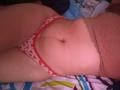 AntoniaBrunni's soft belly with a visible navel, wearing red and white heart-patterned panties, lace top, lying on a colorful bed, showing her slightly chubby, pale-skinned, curvy lower body.