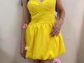 MiraMixi in a bright yellow dress with a cute, flouncy skirt, small tits, red nails, pink flower on her left thigh, and a ring on her right hand.