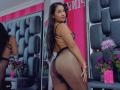HannaHarper with long dark hair, wearing black strappy lingerie and sheer pantyhose, showing her ass, standing in front of a mirror, looking back with a slight smile.