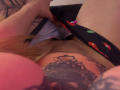 MiaValenttine's black underwear with red and green patterns is being pulled down, exposing her hairy pussy. A tattoo is visible on her lower abdomen. Her hand is holding the underwear.