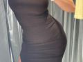 MargoFun's black, ruched dress shows off her curvy, tight-ass and slim waist. Her arm, wearing a white bracelet, is partially visible on the right.