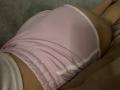 Olieri's pink, tight, sheer shorts are hugging their big, round ass. The fabric is slightly wrinkled, showing their bare, tan skin underneath.
