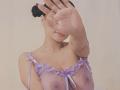 Yurimy with dark hair in buns, wearing a sheer purple top, covering her face with a raised hand, showing her small nipples and tits, against a plain background.