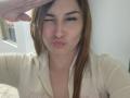AnaEox has brown hair, a pimple on her nose, and is making a puckered face with her lips. She's wearing a beige hoodie, and someone's hand is saluting.