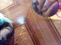Caylin's brown pussy in a mirror, showing her shaved vulva. She's wearing black pants with a teal fuzzy scarf. The wooden floor has ornate patterns.