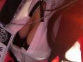 KiraBerry's large boobs are visible through a low-cut white shirt with a black tie, showing plenty of cleavage. Her long brown hair is on the right side.