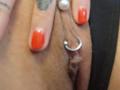 FrenchShanna's pink pussy with a silver ring in the clitoral hood, being touched by FrenchShanna's fingers with shiny red nail polish, showing a tattoo on the hand.