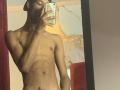 AndyCris, shirtless, holding phone, taking mirror selfie, showing toned abs, slim build, dark skin, wearing black cap, no pants, visible butt hole, in dimly lit room.