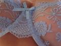 FrenchShanna's tits covered in light blue, floral lace lingerie with a small ribbon, showing intricate patterns and semi-transparent fabric.