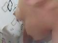 CamilaNoer's tits are visible in a shower, water droplets on her tan skin, nipples slightly erect, upper body in frame, partially covered by white, patterned shower curtain.