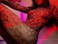 Tsukerberg in a black lace fishnet bodysuit, exposing her tits and pussy through the pattern, sitting with legs raised, red and purple lighting on her fair skin.