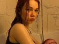 KatiRokisky with wet red hair, looking over shoulder in a shower, wearing a black top, showing her small tits and freckled face, holding a purple mesh garment.