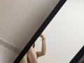 MoonLiza's bare back and raised arm, showing a thin bracelet, in a diagonal mirror shot. Her tits are partially visible, reflecting on the mirror.