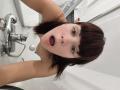 OrianaLaFrancaise, avec des cheveux bruns, une frange et la bouche ouverte, nue dans une salle de bain aux carreaux blancs, tenant un selfie, montrant de petites seins et une expression surprise..