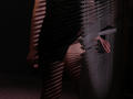 TriciaBarnes' bare ass and thighs, partially shadowed by blinds, with her left hand resting on a dark, vertical surface, showcasing her pale skin and subtle pink lighting.