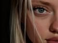 CrystalHope's blue-green eye with long, dark eyelashes, pale skin, and blonde hair in the foreground, showing a slight pout and subtle makeup. Her nose is partially visible.