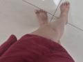JoannaSia's bare legs and feet, with pink-painted toenails, standing on white-tiled floor, wearing a red towel around her ass. Her skin is light.