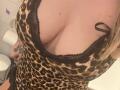 XimenaBella's big, bare boobs in a leopard-print, lace-trimmed, low-cut dress, with a black ribbon on the side. Tattoo on her right arm. Blonde hair, light skin.
