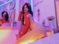 MelisaDaltonn, naked, wearing red fishnet sleeves, kneeling on bed, butt up, looking at camera, dark hair, red bow, purple-blue neon lighting, reflection in mirror, puffy white pillows.