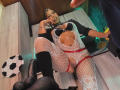 LaurenHills in white fishnet lingerie, black bra, and red garter, legs spread, showing her pussy, black boots, talking on phone, man's dick in frame, soccer ball.
