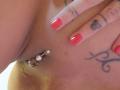 Shanna, eine Französin, ließ ihre Vulva mit einer silbernen Kugel und einem Verschluss durchstechen, trug rot lackierte Nägel, ein Tattoo an ihrer Hand und ein weiteres Tattoo an ihrem rechten Hüfte..