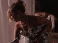 RosaVance with wavy blonde hair in a bun, wearing a sparkly silver dress, pearl necklace, and earrings, bending forward, showing her tits and ass in soft, dim lighting.