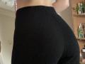 I leggings neri a coste di Ramilla, che esaltano i glutei, sono aderenti e strutturati, mettendo in risalto il suo sedere rotondo e prominente. La sua parte bassa della schiena è visibile, evidenziando la sua figura slanciata e sinuosa..