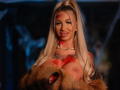 CelineDian with long blonde hair, red face paint, tattoos, large bare boobs, holding a furry teddy bear, pearl necklace, smiling, warm lighting, Brazzers watermark.