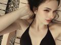 AdrianePittillo has small tits, pale skin, and dark hair, wearing a black halter bikini, winking with a hand in her hair, looking cute and sexy.
