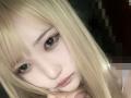 MarthaLipkind has blonde hair, fair skin, and brown eyes with subtle makeup. She's looking down with a slightly sad or thoughtful expression. Her nose is small and her lips are pink.