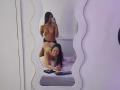 DakotaandJuliette with long black hair, topless, showing tits, wearing black panties, standing, holding phone, reflected in mirror. DakotaandJuliette, smiling, naked, kneeling, on bed, with ass up.