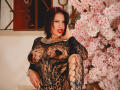 DonnaJones with black lace outfit, showing her tits through the fabric, sitting next to a cherry blossom tree, looking sexy with red lipstick and dark hair.
