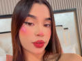 LunaVali with pink blush on her cheeks, glossy red lips, and long brown hair, looking directly at the camera, showing off her cute face and sexy expression.