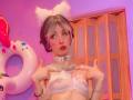 LaurenEvie69 with cat ears, white lace bra, pink blush, collar, and pointed fingers, showing off small tits, short blonde hair, red lipstick, and tattoos. Pink and purple lighting.