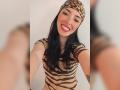 MartinaRey with long black hair, leopard headband, and striped top, smiling at the camera. Her tits are covered, and she's showing her red lipstick and white teeth.