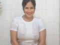 IvannaDuran with wet white shirt, showing her big tits and nipples, smiling in a shower with tile walls, her dark hair pulled back, water dripping on her skin.