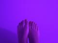 MargoFun's bare feet with painted toenails, standing up, against a purple background, showing soles and toes. Feet are centered, slightly apart, with a subtle shadow on the left.
