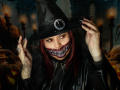 VanesaMoka in witch cosplay, black hat with silver ring, red eyes, striped mask, black leather jacket, long nails, holding hat, spooky, Halloween vibe, dark, goth, sexy.