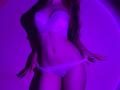 FlyFreedom with pink-purple lit skin, wearing white lace bra and panties, pulling down her panties, showing her flat stomach and small tits. Long wavy hair, sexy, slim.
