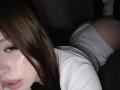 TaniaRaffa lying on her stomach, wearing white panties and a ribbed shirt, with her ass raised and brown hair covering her face, showing a small tear on her cheek.