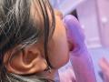 SarahPrincess's face with black hair, nose ring, and earring, sucking a purple, translucent dildo. Her tongue's wrapped around the dildo's head, showing it's in her mouth.