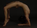 KamiLove is doing a backbend with her ass up, pussy slightly visible, and her tits pressed against the floor. She has dark hair in a ponytail, and is nude.