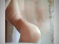 KaiaLein's bare, rounded ass is in focus, showing smooth, light skin with a slight tan. The background is blurred, highlighting KaiaLein's curvy, soft buttocks.